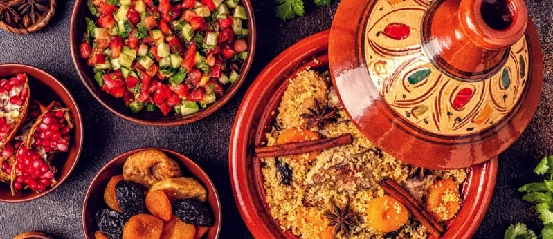 A table adorned with a variety of Moroccan dishes, showcasing vibrant colors and rich textures of traditional cuisine.